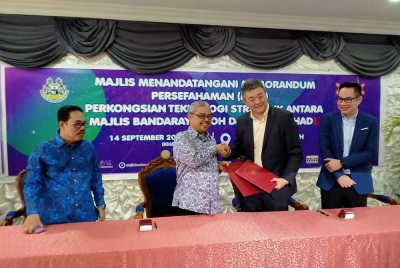 Pertukaran dokumen antara Rumaizi (dua dari kiri) dan Roy Ho (dua dari kanan) pada Majlis MoU Perkongsian Teknologi Strategik di antara MBI dan XOX Berhad di Bangunan MBI di Ipoh pada Khamis.