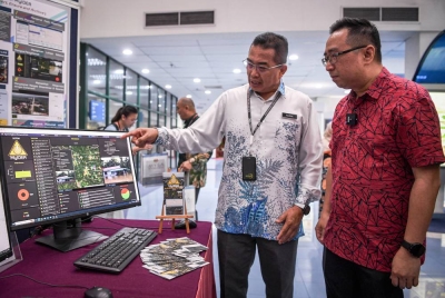 Pengarah Bahagian Aplikasi Perisikan Pertahanan (BP), Datuk Abd Razak Sipit (kiri) menerangkan Sistem Maklumat Bencana (MyIDEA) yang dibangunkan oleh MySA kepada Lih Kang (kanan) pada MySA Spacetech Showcase 2023 hari ini. - Foto Bernama