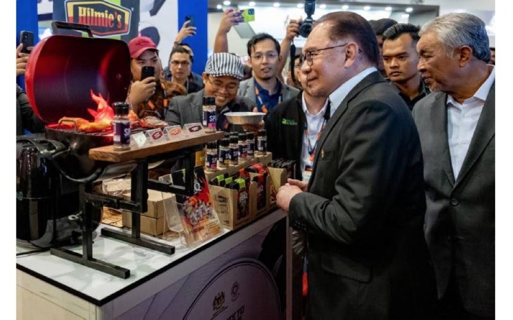 Anwar dan Ahmad Zahid (kiri) meninjau salah satu produk halal tempatan yang dipamerkan sempena majlis pelancaran Global Halal Summit (GHaS) 2023 di Kuala Lumpur pada Selasa.