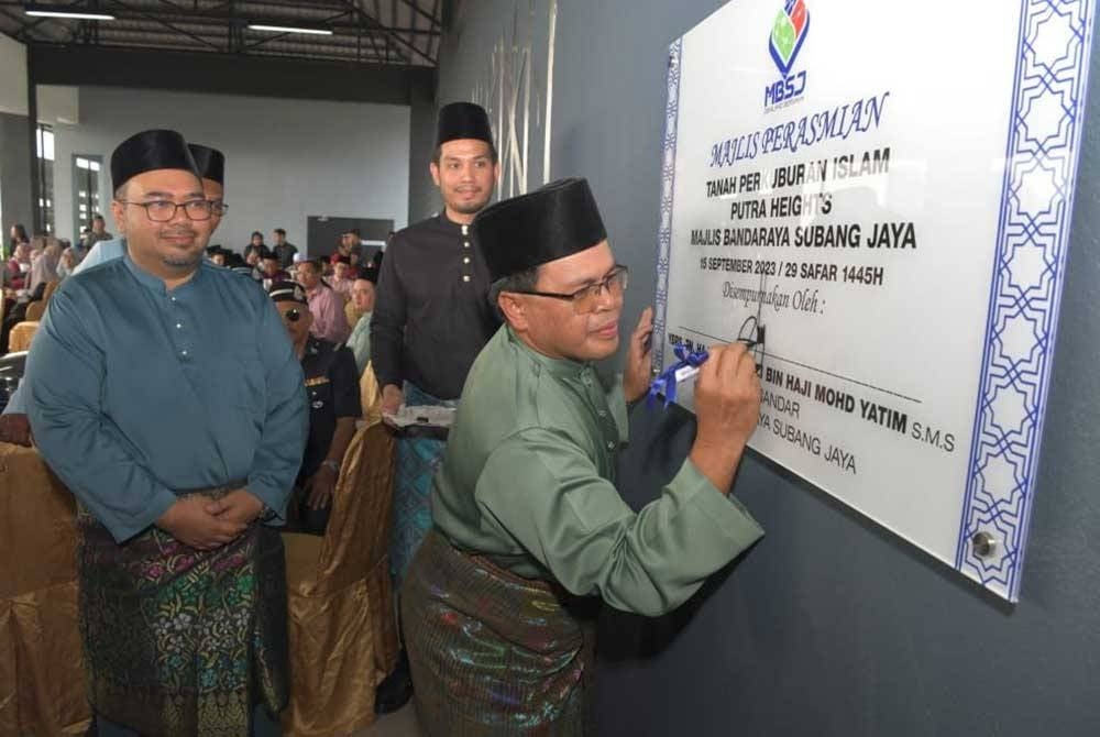 Mohd Fauzi menandatangani plak semasa Majlis Perasmian Perkuburan Islam Putra Heights, MBSJ di Jalan Kemboja, Kampung Kuala Sungai Baru, Puchong pada Jumaat.