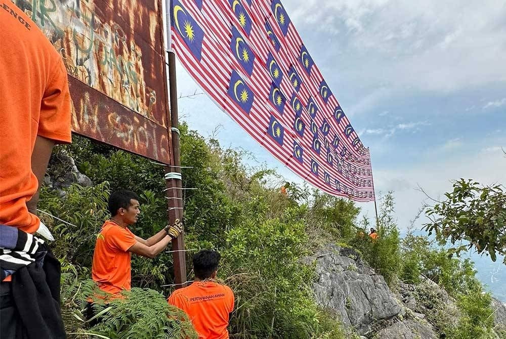 Peserta memasang Jalur Gemilang di puncak Gunung Baling. - Foto: APM Kedah