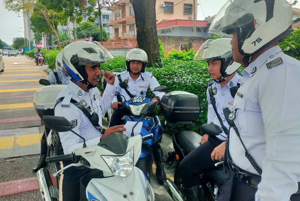Sekumpulan anggota unit trafik PDRM berbincang mengenai tugasan masing-masing di ibu kota Kuala Lumpur.