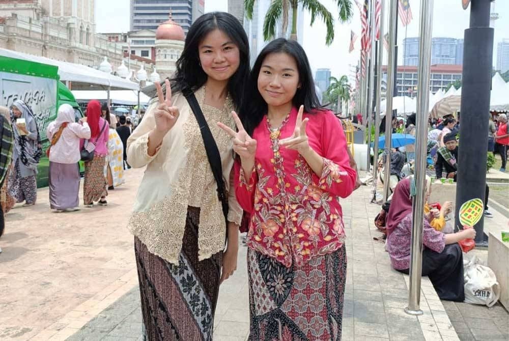 Kayleigh (kiri) dan rakan mengenakan kebaya tradisional.