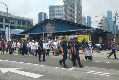 Anggota polis mengiringi kumpulan Himpunan Aman Selamatkan Malaysia menuju ke IPD Dang Wangi, Kuala Lumpur pada Sabtu.