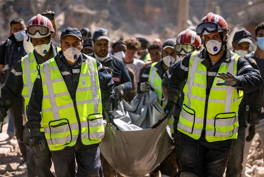 Pekerja penyelamat membawa mayat yang ditemui daripada runtuhan rumah yang musnah akibat gempa bumi Mahribi di kampung Imi N'Tala berhampiran Amizmiz pada 13 September lalu. - Foto AFP