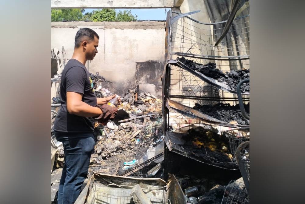 Safuan melihat barangan di kedainya yang musnah dalam kebakaran.