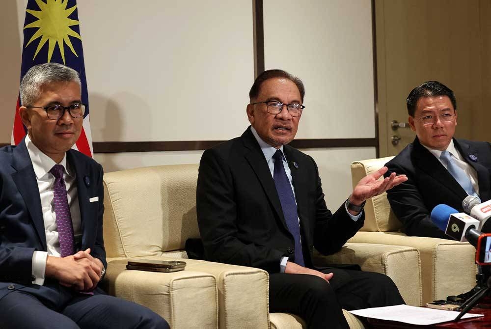 Anwar (tengah) pada sidang media selepas menghadiri Ekspo China-ASEAN dan Sidang Kemuncak Perniagaan dan Pelaburan China-ASEAN pada Ahad. - Foto Bernama