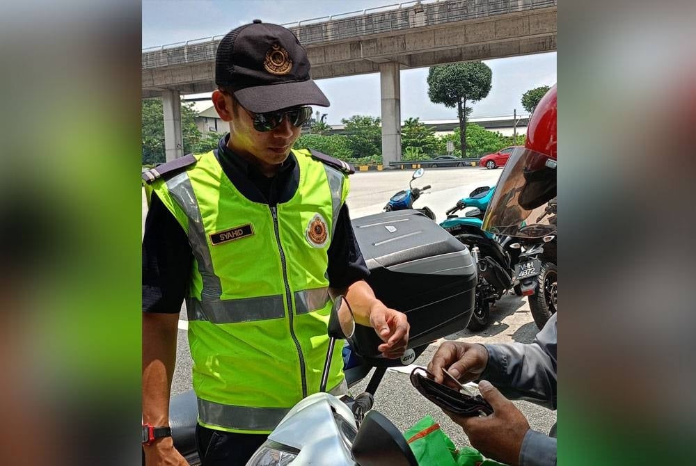Anggota JPJ memeriksa penunggang motosikal dalam operasi Ops Merah 2023 yang dilaksanakan pada Ahad.