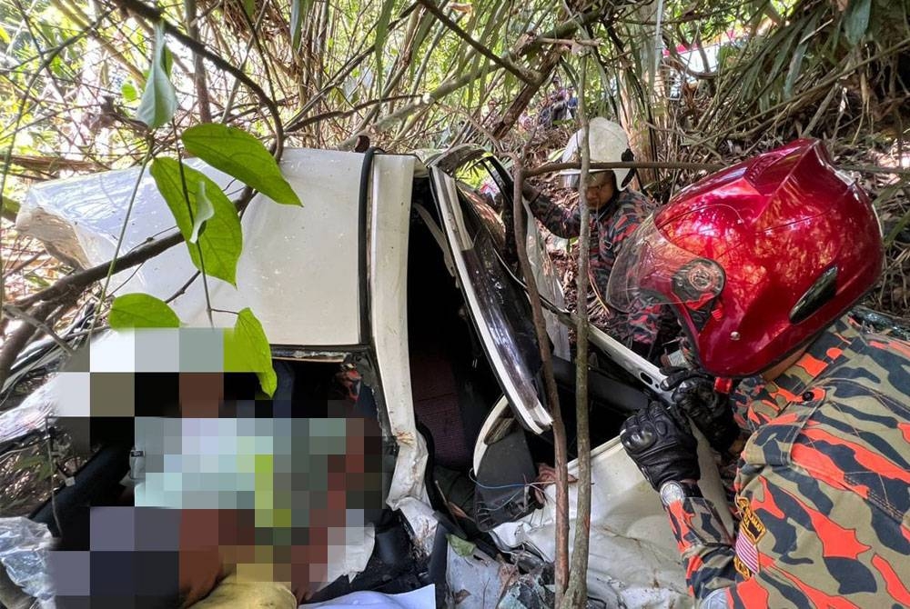 Pasukan bomba memeriksa keadaan mangsa yang tersepit dalam kereta di Jalan Tapah - Cameron Highlands, Tapah pada Isnin. - Foto ihsan bomba