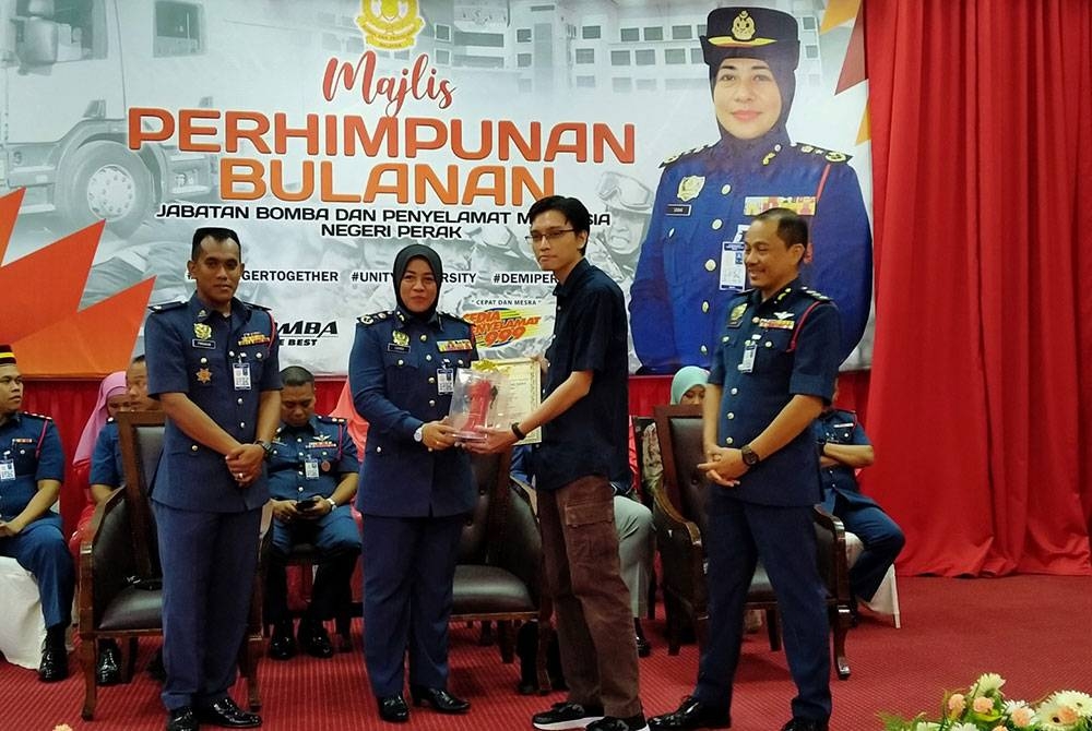 Sayani (dua dari kiri) menyampaikan sijil Teman Pili Bomba kepada orang awam.