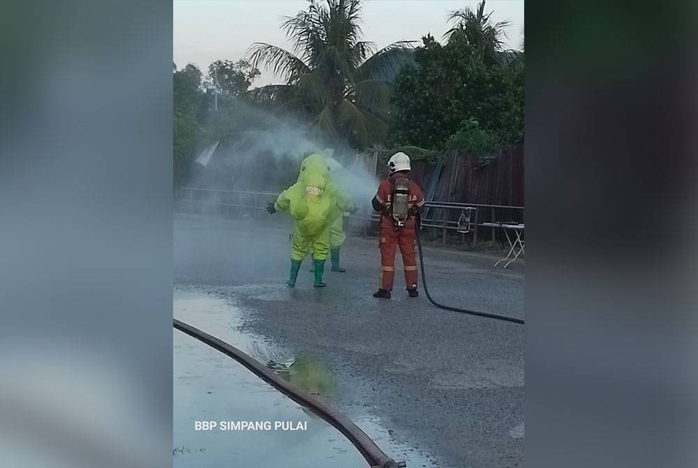 Pasukan bomba membantu membilas anggota Hazmat yang menjalankan operasi gas ammonia bocor di sebuah kilang ais di Simpang Pulai pada Selasa. Foto: Ihsan Bomba