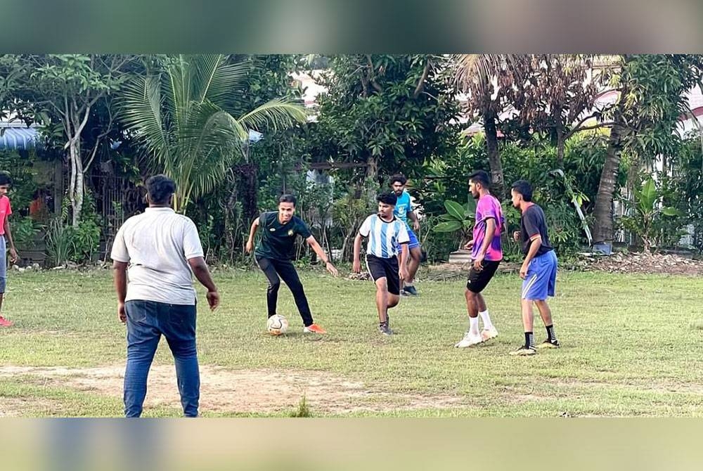 Baddrol (dua kiri) mendekati belia India melalui sukan bolasepak di Taman Gurun Jaya, Gurun baru-baru ini.