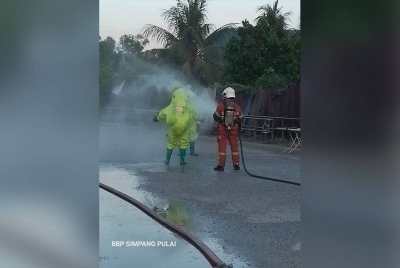 Pasukan bomba membantu membilas anggota Hazmat yang menjalankan operasi gas ammonia bocor di sebuah kilang ais di Simpang Pulai pada Selasa. Foto: Ihsan Bomba