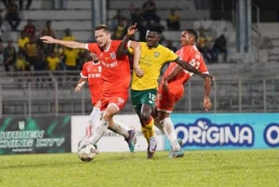 Pemain Kedah, Ifedayo Olusegun (kanan) berusaha melepasi kawalan Mihailo Jovanovic dari Kuching City dalam perlawanan suku akhir pertama Piala Cabaran di Stadium Negeri. FOTO: Kedah Darul Aman FC