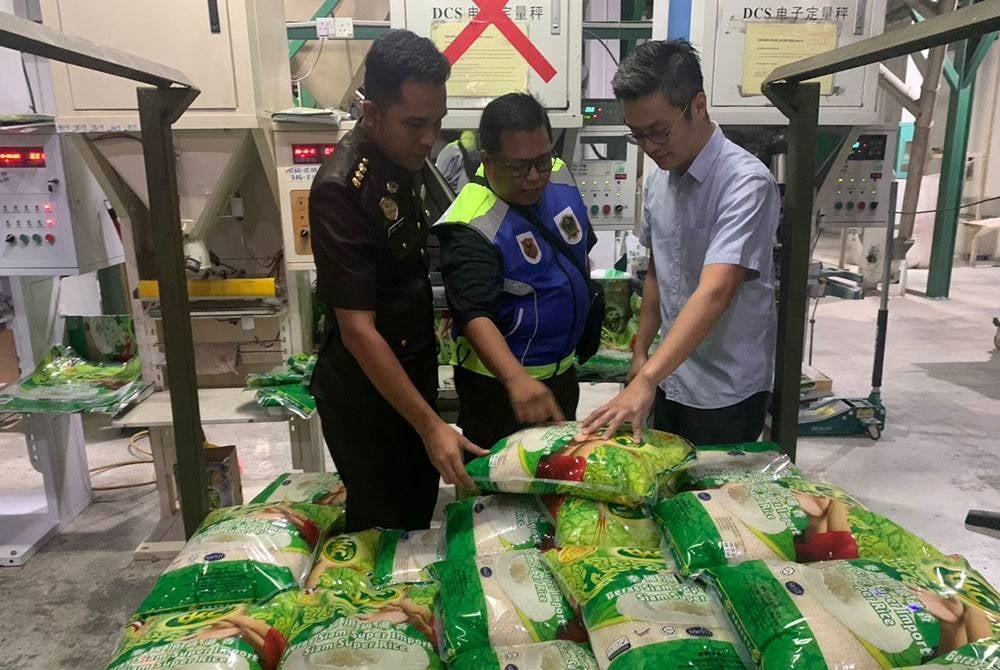 Ab Alim (kiri) ketika memantau operasi kilang memproses dan pembungkusan beras di Kota Kinabalu.