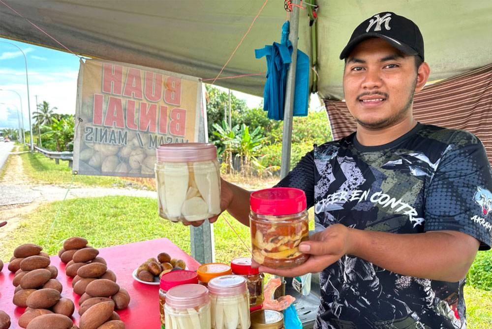 Muhammad Akram menunjukkan jeruk binjai yang dijual dengan harga RM20 sebotol bersaiz kecil.