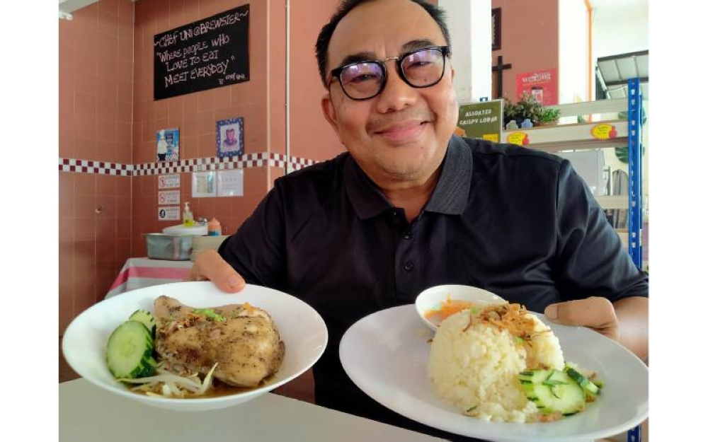 Ahmad Khusaini menunjukkan hidangan ayam garam halal yang popular di bandar raya Ipoh.