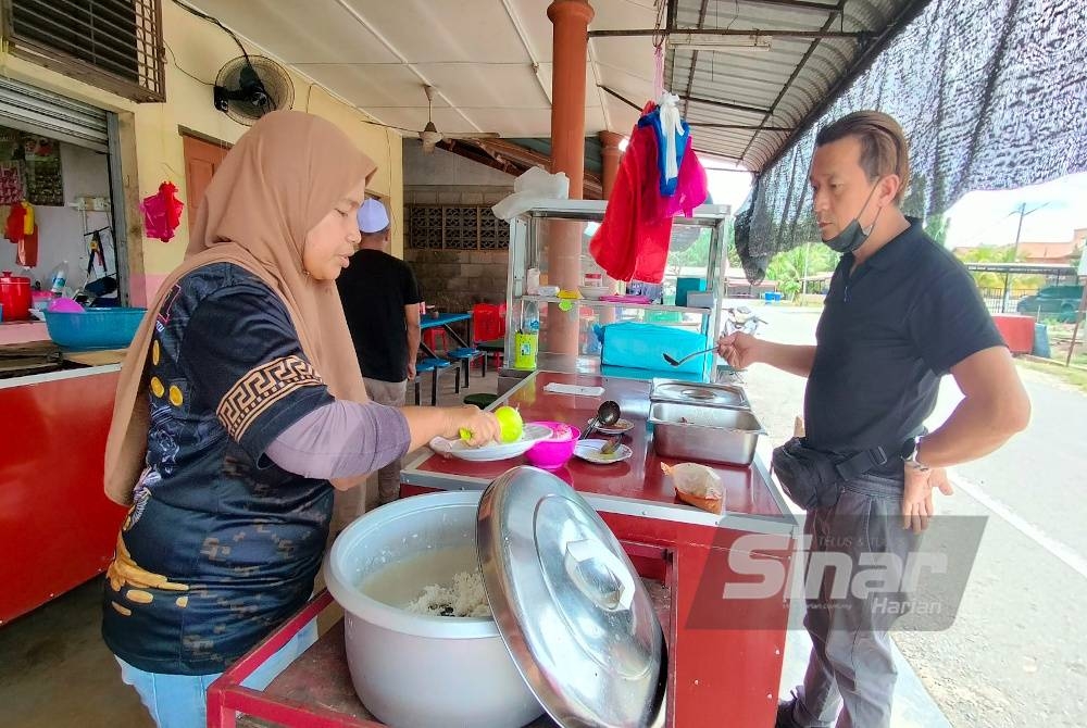 Zaihazlen melayan pelanggan yang datang digerainya di Felda Chemomoi di sini pada Jumaat.