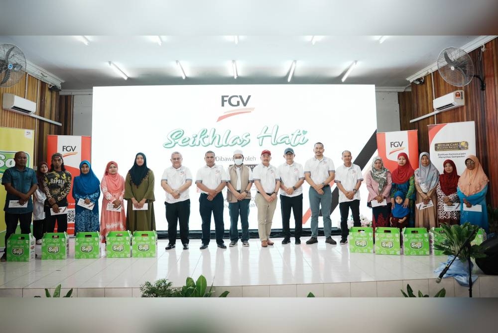 Ruslan (sembilan dari kanan) dan tetamu kehormat yang lain bergambar bersama sebahagian penerima sumbangan majlis FGV Seikhlas Hati.