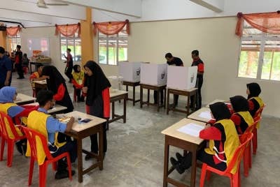Pelajar SMK Sungai Burong melaksanakan tanggungjawab 'mengundi' pada simulasi pilihan raya di sekolah terbabitpada Jumaat.