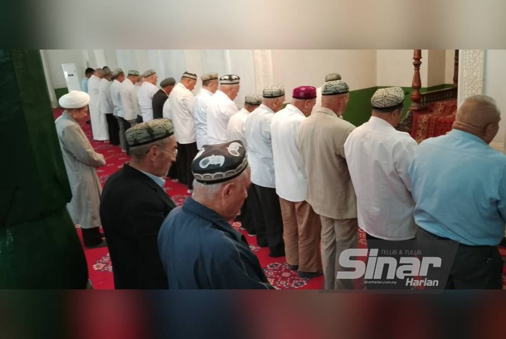 Lelaki warga emas Uighur menunaikan solat Zohor di Masjid Id Kah. - FOTO AFDAH MUJAP