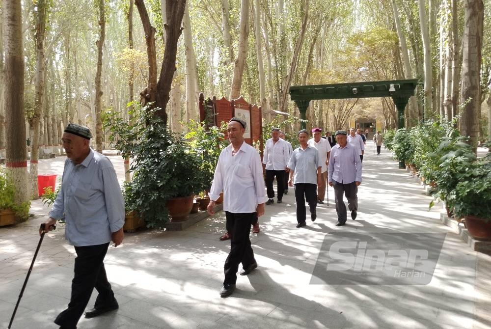 Sekumpulan lelaki Uighur menuju ke pintu keluar Masjid Id Kah selepas selesai menunaikan solat Zohor. - FOTO AFDAH MUJAP