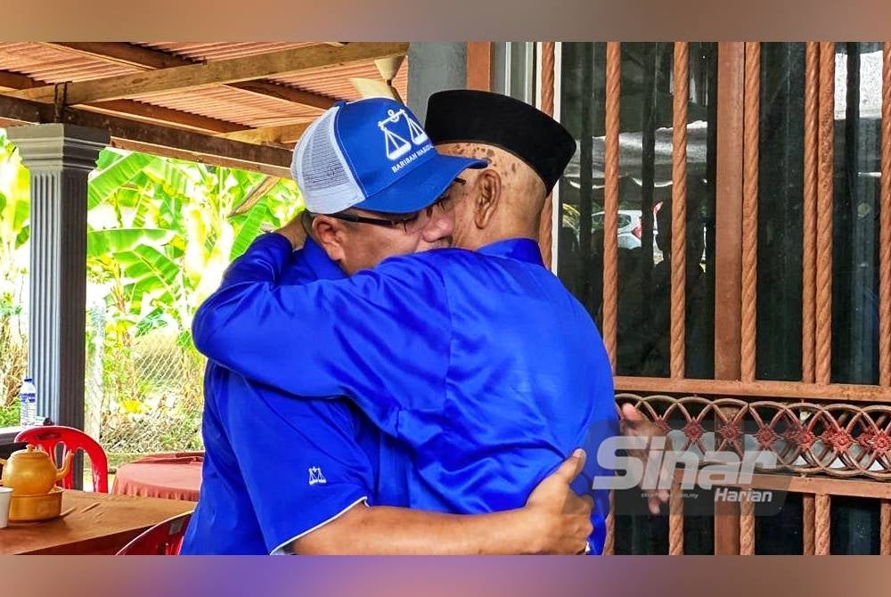 Amizar berpelukan dengan bapanya ketika ditemui di kediaman keluarga itu di Felda Chemomoi pada Sabtu.