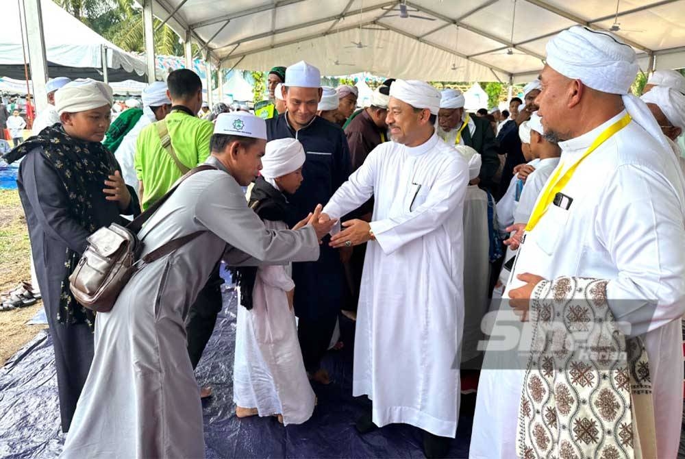 Orang ramai mengambil peluang bersalaman dengan Mohd Nassuruddin (dua dari kanan).