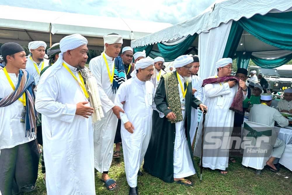 Mohd Nassuruddin (depan, dua dari kiri) berjalan beriringan dengan Wazir (dua dari kanan) pada Program Pondok-pondok Berselawat di Pasir Puteh.