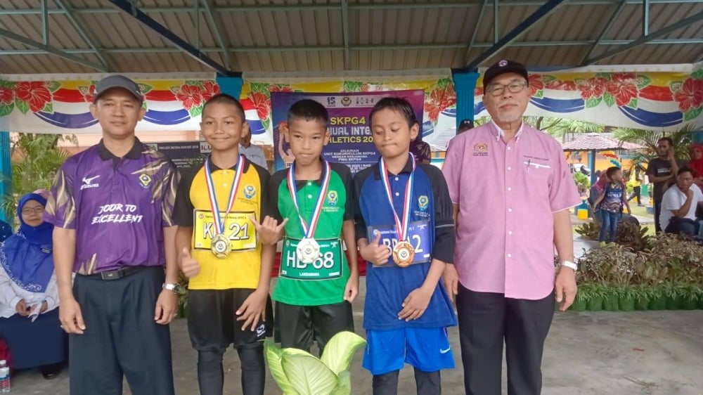 Hassan (kanan) bersama para pemenang selepas merasmikan Sukan Sekolah Kebangsaan (SK) Pasir Gudang 4, Pasio Gudang pada Ahad.