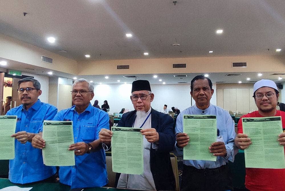 Mohd Azmi Abdul (tengah) bersama Hadzir (dua dari kiri) dan Dr Abdul Rahman (dua dari kanan) menunjukkan deklarasi selepas pelancaran SAF pada Ahad.