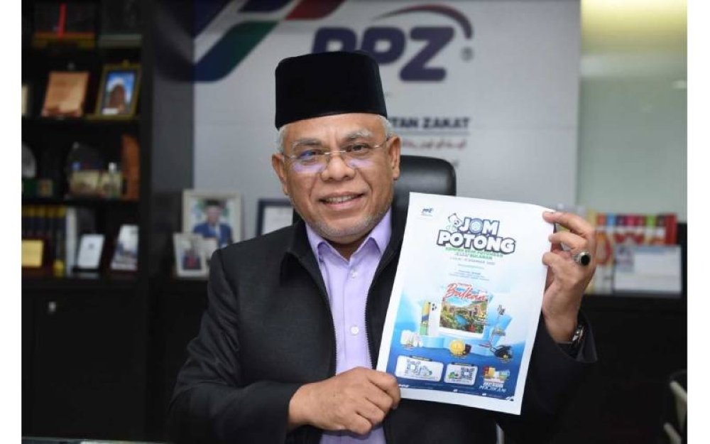 Abdul Hakim menunjukkan risalah Kempen Jom Potong Skim PZB bagi menggalakkan umat Islam menunaikan zakat secara potongan gaji melalui PPZ-MAIWP.