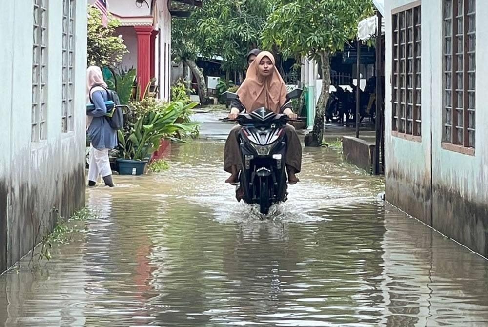 Penduduk Kampung Masjid meredah banjir kilat yang melanda kampung itu sejak jam 6.30 pagi.