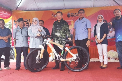 Rizam (tengah) menyampaikan hadiah cabutan bertuah kepada salah seorang pemenang pada Program Hari Terbuka PPD Kuala Selangor 2023 di Tapak Parkir Lotus's Kuala Selangor pada Isnin.
