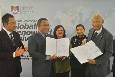 Mohd Sazili (dua dari kiri) bersama Musa (dua dari kanan) menunjukkan Memorandum Persefahaman (MoU) yang ditandatangani.