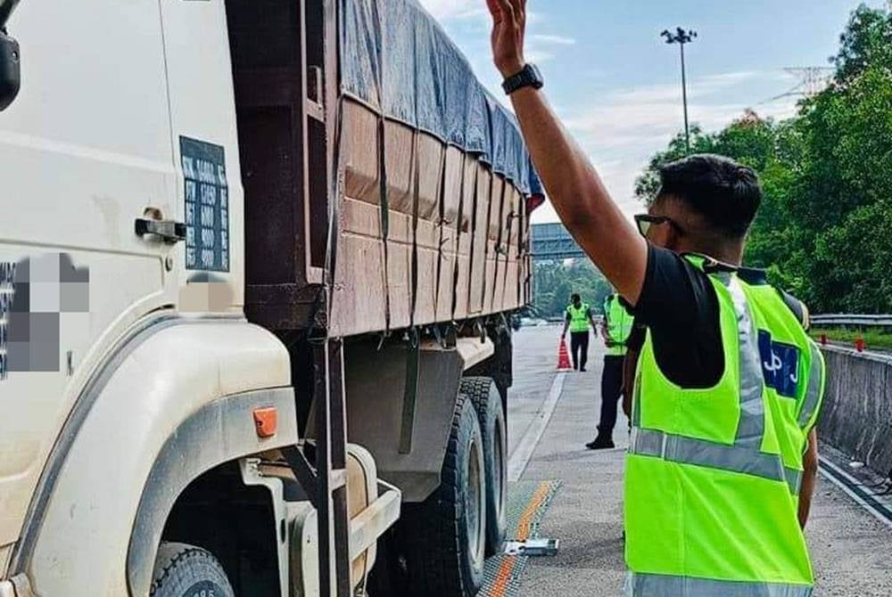 Anggota JPJ menahan sebuah lori untuk diperiksa. Gambar hiasan.