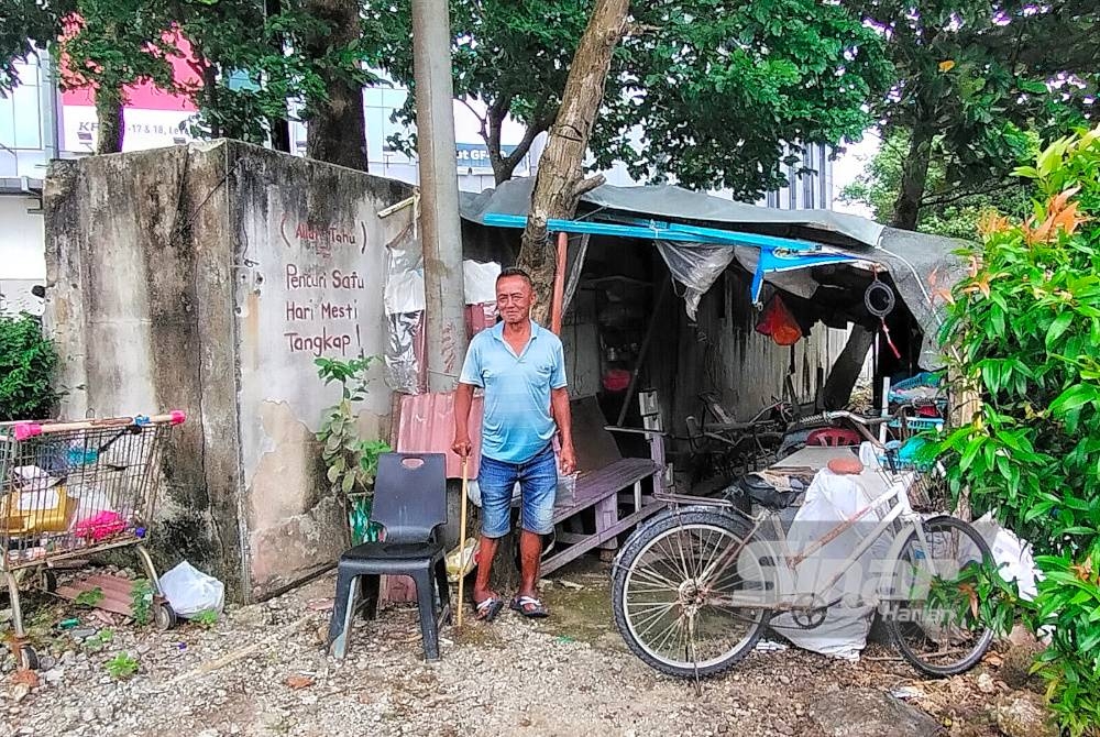 Hock Chuang berdiri di depan pondok yang dibinanya berhampiran sebuah pusat beli-belah di Jalan Bunga Raya, di sini, sejak tiga tahun lalu.