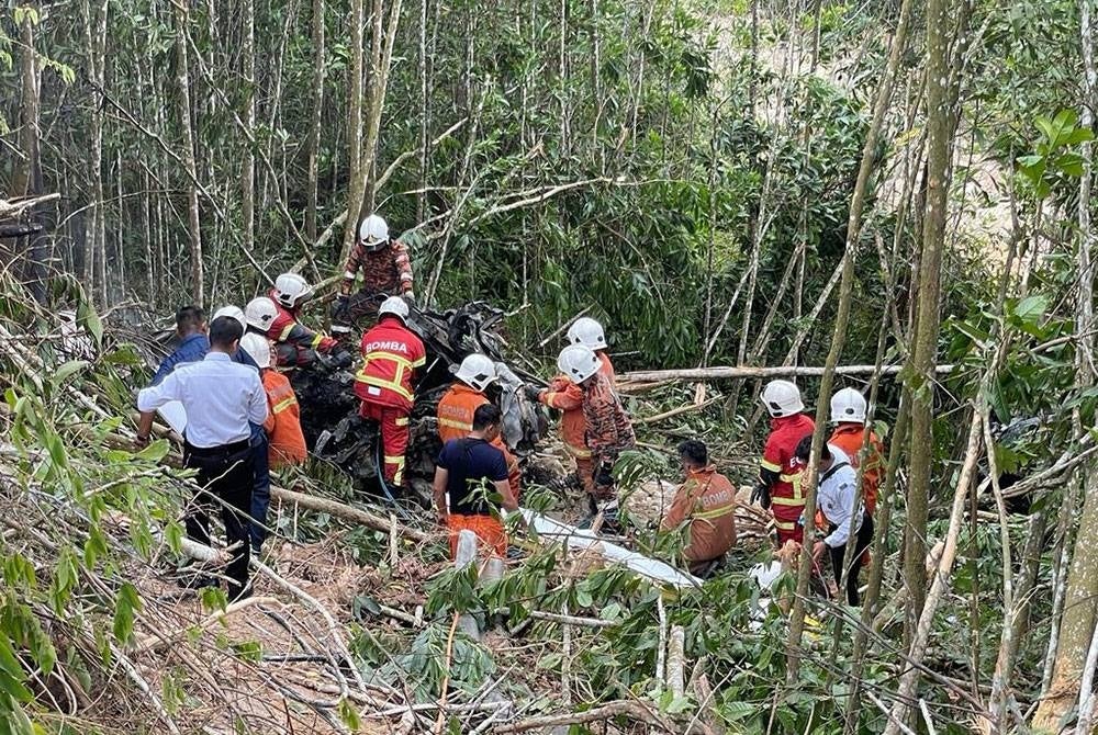 Anggota bomba mengeluarkan mangsa yang maut di dalam sebuah kereta yang terbakar selepas terlibat nahas dengan sebuah lori mengakibatkan kedua-dua kenderaan itu jatuh ke lereng bukit berketinggian enam meter dalam kejadian di Jalan Seremban - Kuala Klawang berhampiran Jeram Toi, di sini pagi Selasa. - Foto Bomba Negeri Sembilan