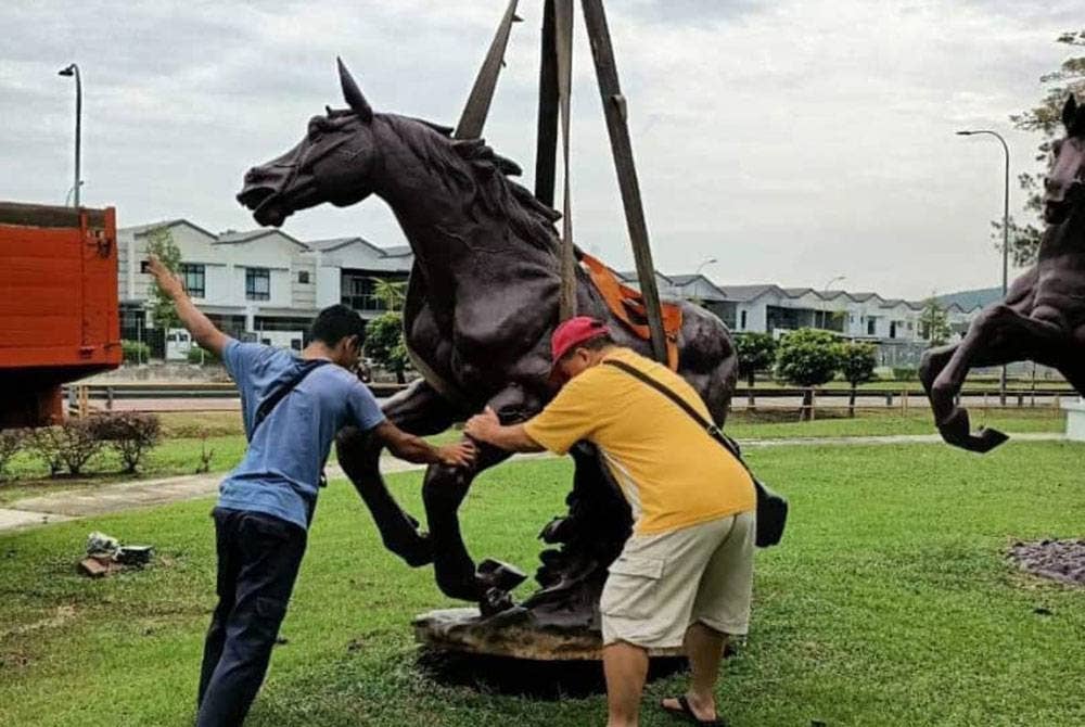 Kerja-kerja meletakkan semula replika kuda hiasan yang berjaya ditemui semula selepas dicuri di Taman Sri Pulai Perdana.