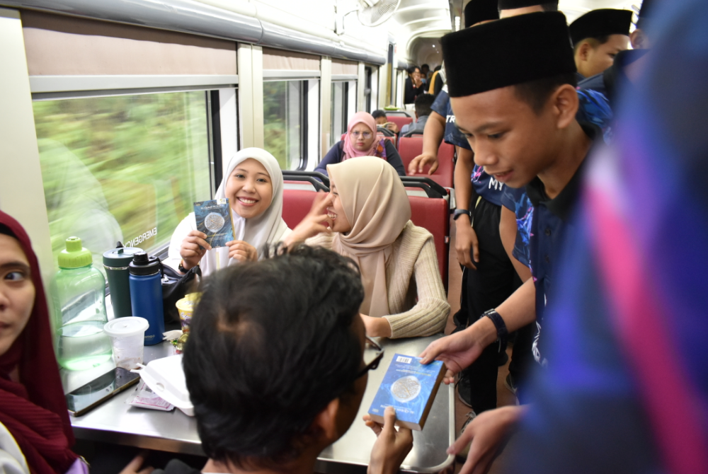 PELAJAR MRSM ATM Bera turut mengagihkan naskhah al-Quran percuma kepada penumpang kereta api ketika perjalanan ke Dabong.