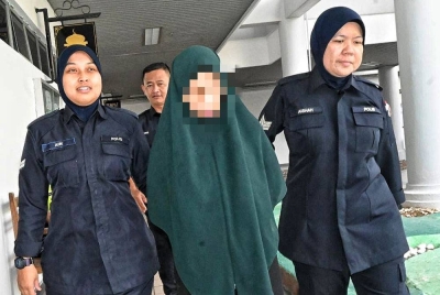 Tertuduh (tengah) ketika dibawa keluar Mahkamah Sesyen Ayer Keroh, pada Selasa selepas pertuduhan dibacakan terhadapnya.