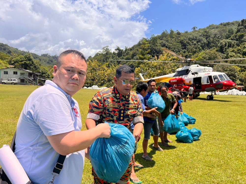 Chun Tak (kiri) daripada FOL bersama Yuszaimi Hairrul Azwan (dua dari kiri) turut terlibat menghantar bekalan makanan ke Pensiangan.