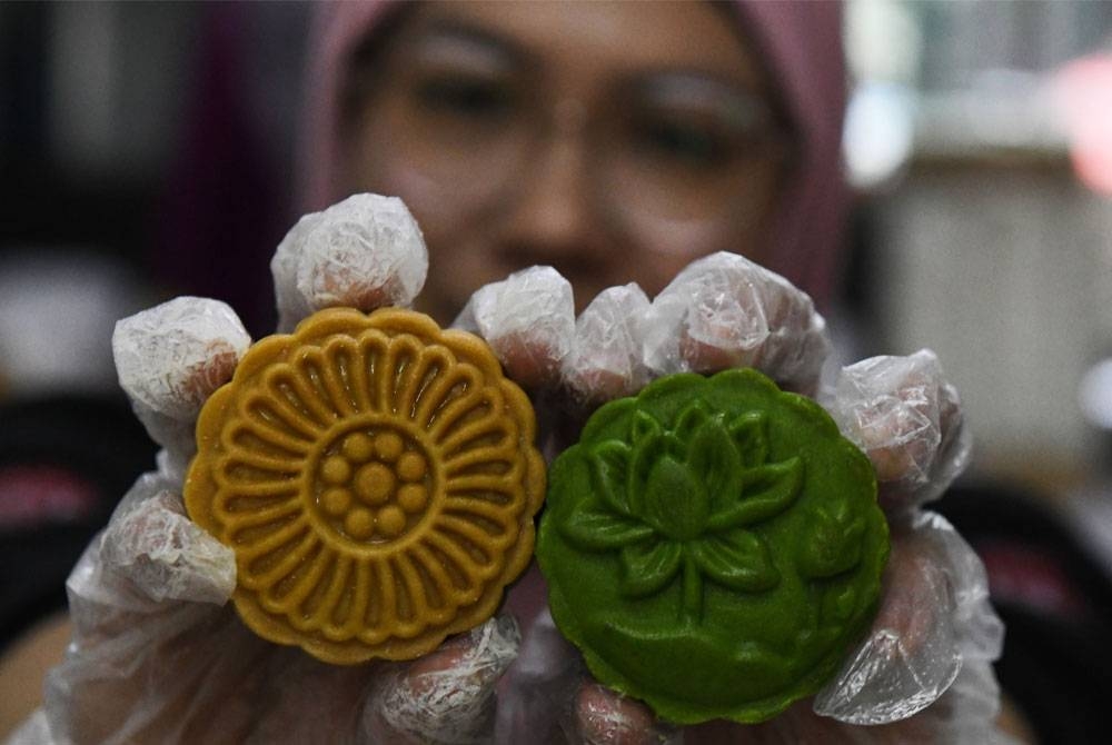 Farrah yang menjual pelbagai jenis biskut dan kuih muih tradisi turut menerima tempias apabila produk kuih bulannya bukan sahaja menjadi pilihan masyarakat Cina malah India dan Melayu. - Foto Bernama