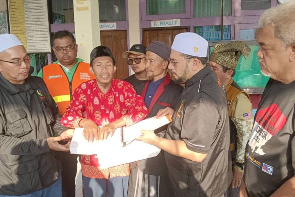 Mas Imran (dua dari kiri), Rozi (dua dari kanan) dan Hashim (kanan) dalam majlis simbolik penyerahan van di Sekolah Yayasan Dewasa Pelita Harapan, Mataram, Lombok Timur, Lombok Timor, Indonesia pada Khamis.