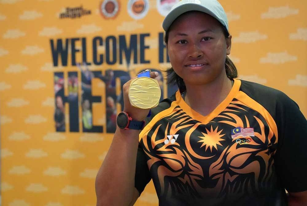Nur Shazrin menunjukkan pingat emas yang dimenangi di Sukan Asia Hangzhou 2022. - Foto FB Majlis Sukan Pahang