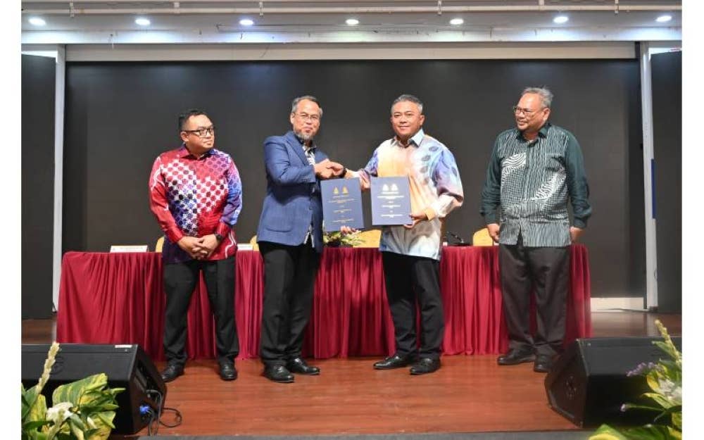 Mohamad Azham (dua dari kiri) bersalaman dengan Mohd Hasry (dua dari kanan) sambil menyerahkan MoU pelaksanaan PBP di antara MBPJ dengan MPHS.