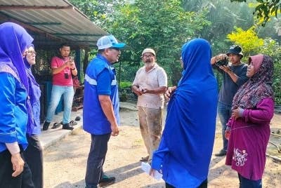 Amizar (dua dari kiri) ketika menyantuni penduduk di Kampung Chemomoi pada Jumaat.