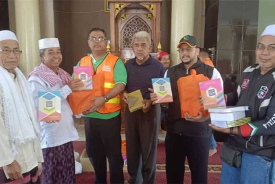Rozi (dua kanan), Mas Imran (tiga kiri) dan Hashim (tengah) menyerahkan Al-quran dan sumbangan bahan makanan di Masjid Jami'Fathurrahman, Desa Pengadangan, Kecamatan Pringgasela, Lombok Timor, Lombok, Indonesia pada Jumaat.