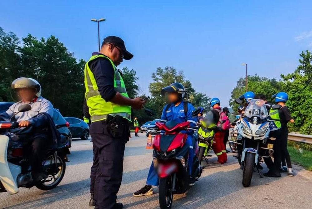 Anggota penguat kuasa JPJ melakukan pemeriksaan ke atas pengguna motosikal pada Operasi Penutup Ops Khas Motosikal Tahun 2023 JPJ Pahang di Jalan Pintasan Kuantan, Semambu di sini pada Jumaat.