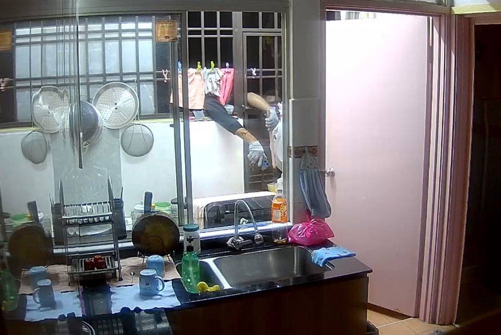 Rakaman CCTV menunjukkan dua individu cuba memecah masuk ke dalam rumah.
